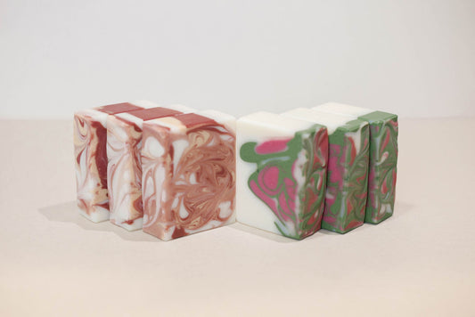 Three bars of handmade soap with marbled patterns on a light background