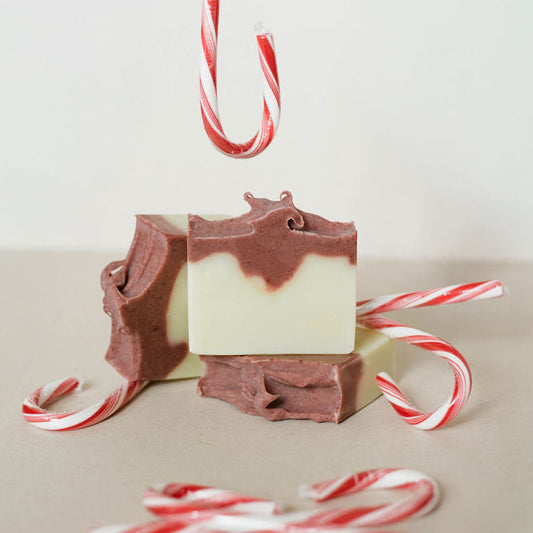 Three handmade bars of soap colored with mauve madder root powder. Candy canes decorating the picture.
