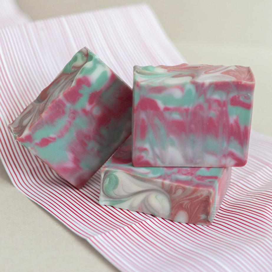 Three handmade bars of soap colored in vibrant layers of green, red and white. Scented with Bramble Berry's autumn fig fragrance oil.