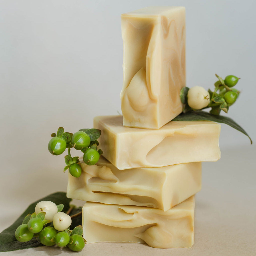 Four vertically stacked homemade bars of soap, lightly colored with yellow clay. Scented with a blend of ginger, lemongrass, and cedarwood atlas essential oils.