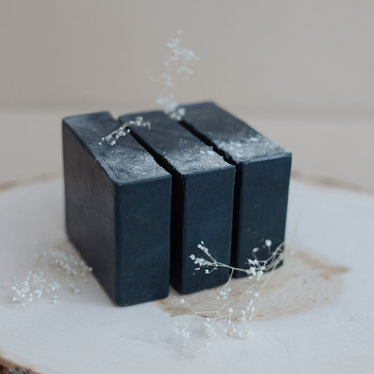 Three black handmade bars of soap made with activated charcoal, tea tree, eucalyptus and lime essential oils