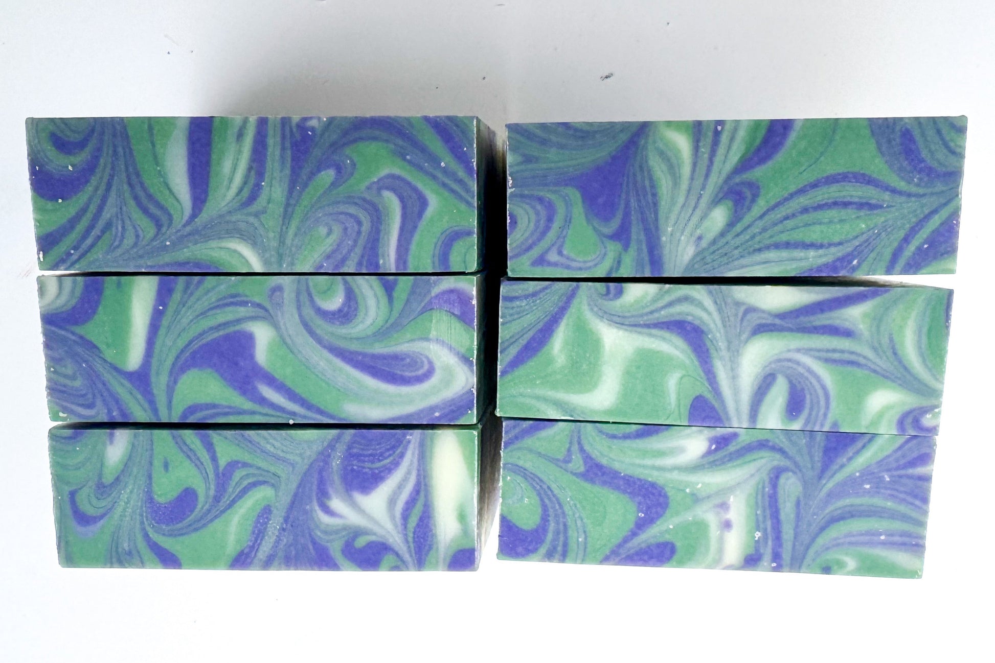 Marbled green and purple soap bars on a white background