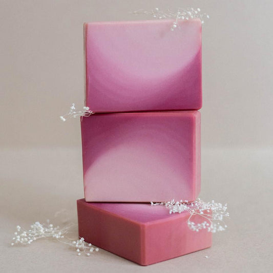 Three handmade bars of soap beautifully colored in a magenta  and white ombre. Scented with Bramble Berry's lingonberry spice fragrance oil