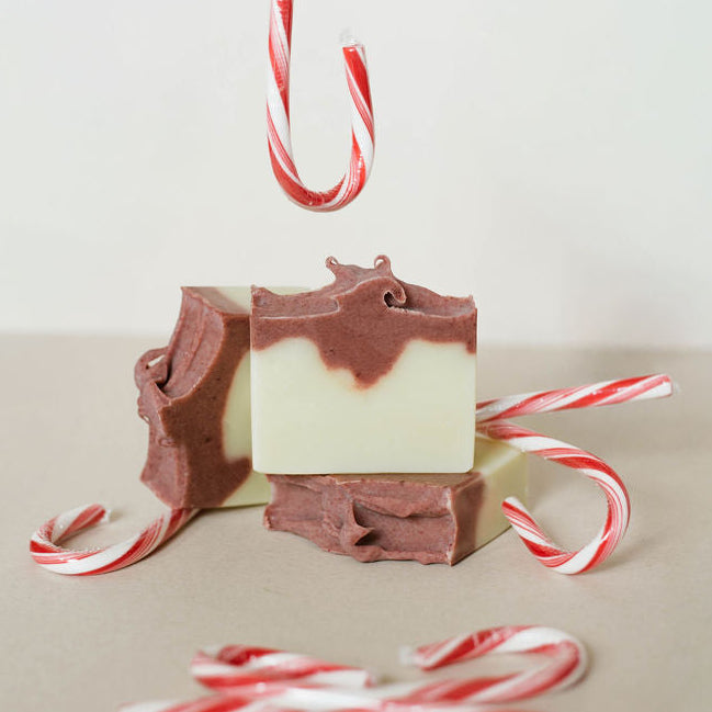 Three handmade bars of soap colored with mauve madder root powder. Candy canes decorating the picture.