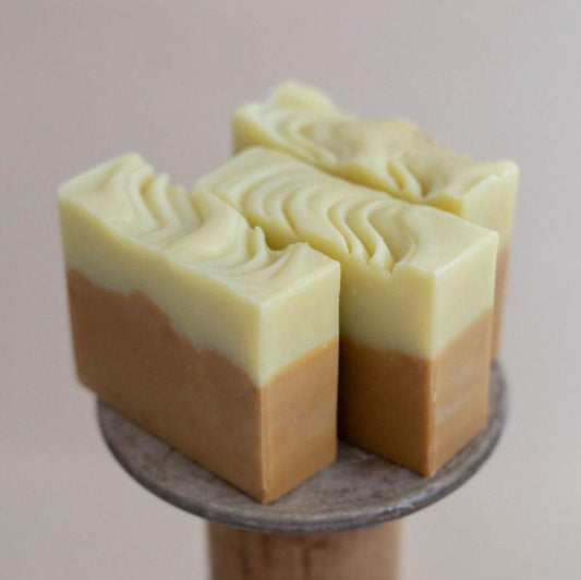 Two handmade  vegan, all natural bars of soap layered in light and mustard yellows. Scented with scotch pine, orange, and patchouli essential oils.